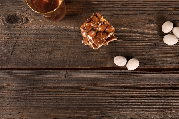 Photo gratuite barre au miel et aux noix avec verre à thé sur la table