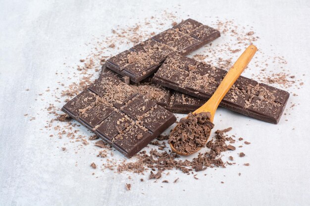 Barre de chocolat avec cuillère et cacao sur fond gris. photo de haute qualité