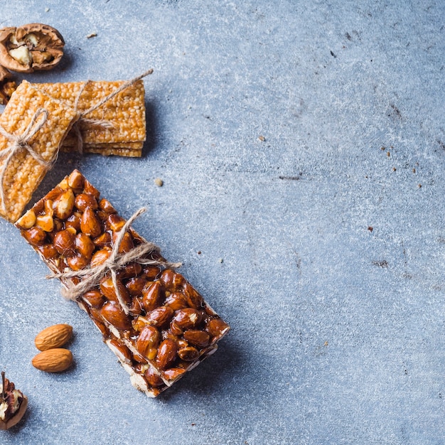 Barre énergétique d&#39;amandes et de sésame attachée avec une ficelle sur un fond en béton