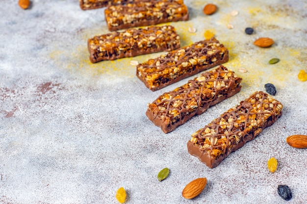 Photo gratuite barres de céréales healthy delicios au chocolat, barres de muesli aux noix et fruits secs, vue du dessus