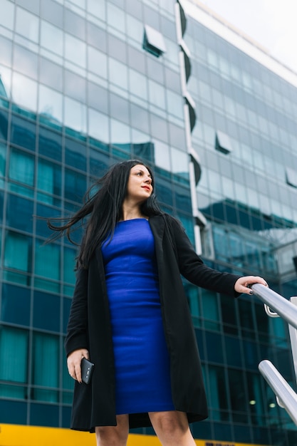 Bas angle, vue, femme affaires, debout, devant, immeuble bureau