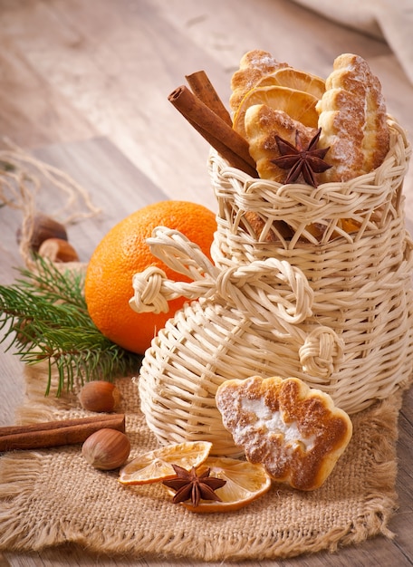 Bas de Noël en osier rempli de biscuits, bâtons de cannelle, citron confit et anis étoilé