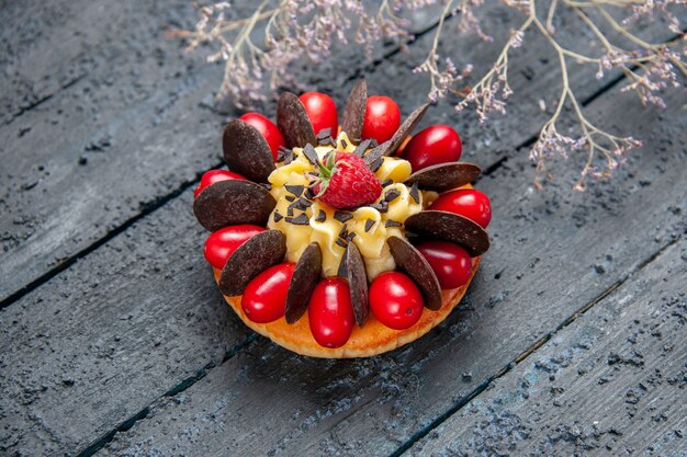 En bas, vue rapprochée avec gâteau aux fruits de cornel framboise et chocolat sur fond de bois foncé