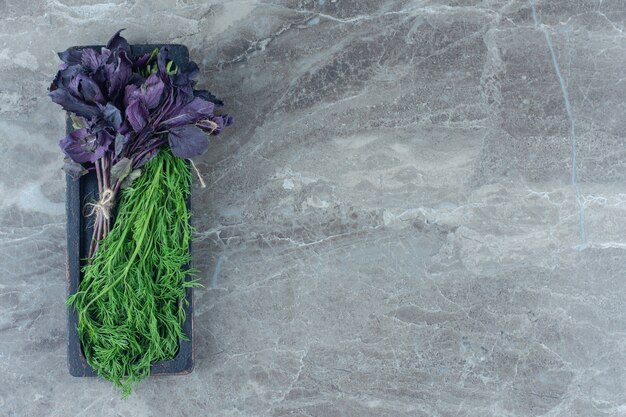 Basilic violet et aneth sur plateau , sur la table en marbre.