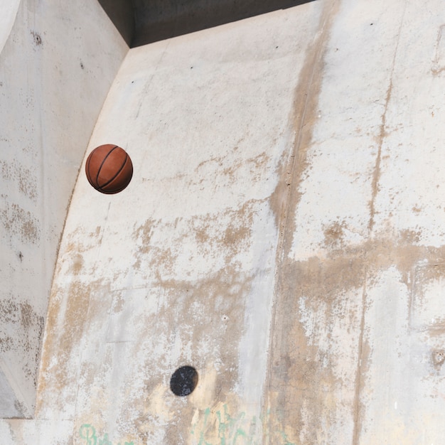Basketball dans les airs contre le mur grunge