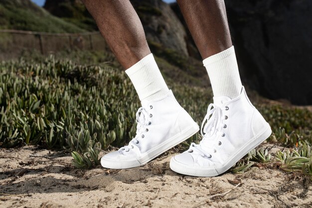 Baskets blanches unies à la cheville pour vêtements pour hommes en gros plan en plein air