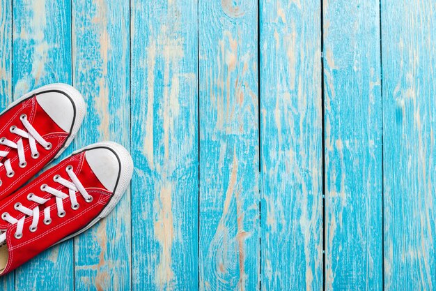 Baskets rouges sur fond en bois.