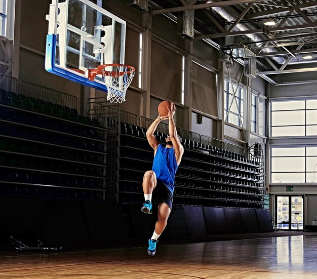 Basketteur professionnel noir en action sur un terrain de basket.