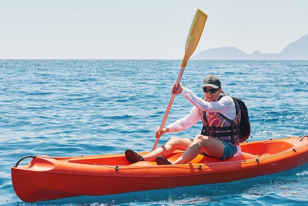 Bateau en kayak près des falaises par une journée ensoleillée. Voyage, concept sportif. Mode de vie.