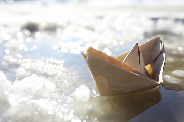 Bateau en papier dans l'eau dans la rue. le concept du début du printemps. la fonte des neiges et un bateau en origami sur les vagues.