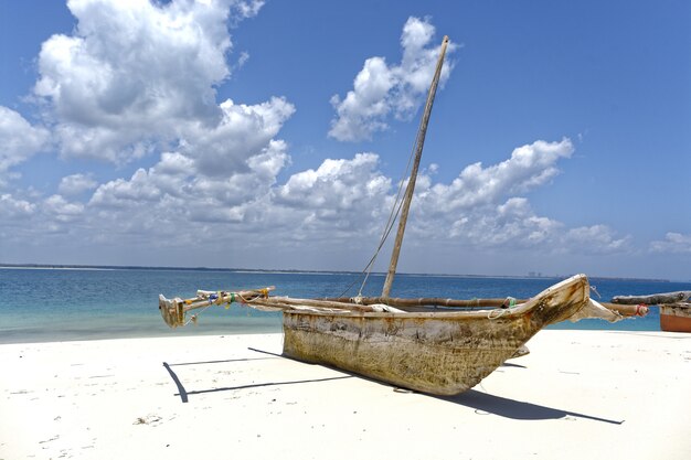 Bateau sur le rivage près de la mer par une journée ensoleillée avec ciel nuageux en arrière-plan