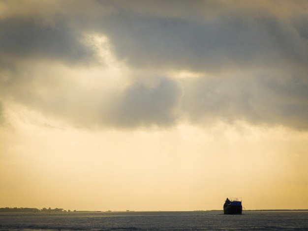 Bateau sur une rivière tropicale avec un ciel nuageux et pluvieux