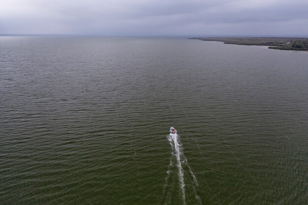 Bateaux de pêche, flottant dans les eaux calmes et allant pêcher sous un ciel avec des nuages