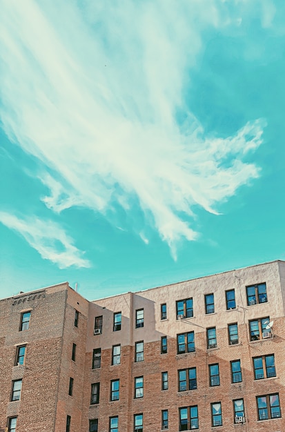 Photo gratuite bâtiment en brique avec fenêtres et ciel bleu