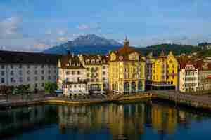 Photo gratuite bâtiments colorés près d'une rivière entourée de montagnes à lucerne en suisse