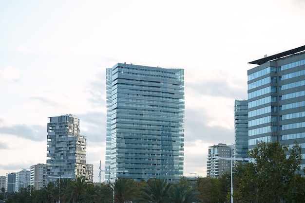 Bâtiments de la ville en béton et verre moderne quelques minutes après le coucher du soleil contre un ciel blanc clair