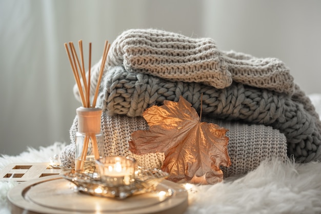 Bâtonnets de bambou aromatique dans une bouteille avec un liquide parfumé avec des bougies restant sur un plateau en bois sur fond flou.