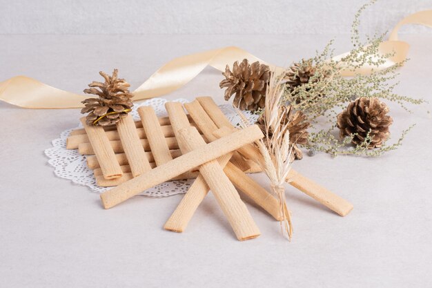 Bâtonnets de biscuits avec pomme de pin sur tableau blanc