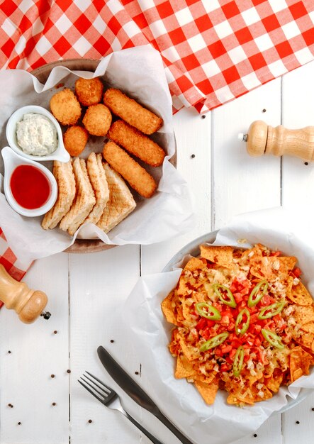 Bâtonnets de boules de fromage et sandwichs avec des nachos sur la table