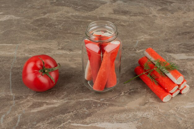 Bâtonnets de crabe en pot avec tomate.