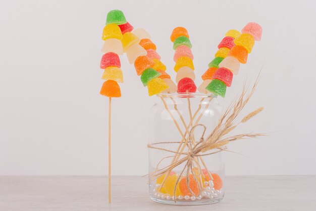 Bâtonnets de marmelades colorées dans un bocal en verre.