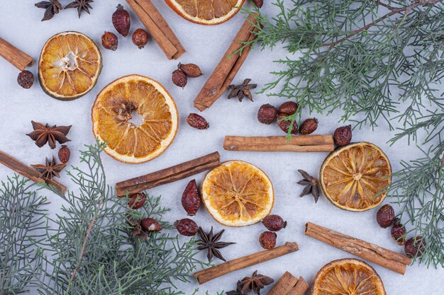 Bâtons de cannelle, cynorrhodons et tranches d'orange séchées en surface.