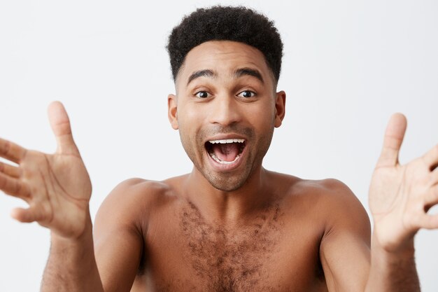 Beau beau père de race mixte à la peau sombre et aux cheveux bouclés va prendre les mains de la petite fille après l'avoir baignée, ayant une expression heureuse, la regardant dans les yeux. Concept de famille.