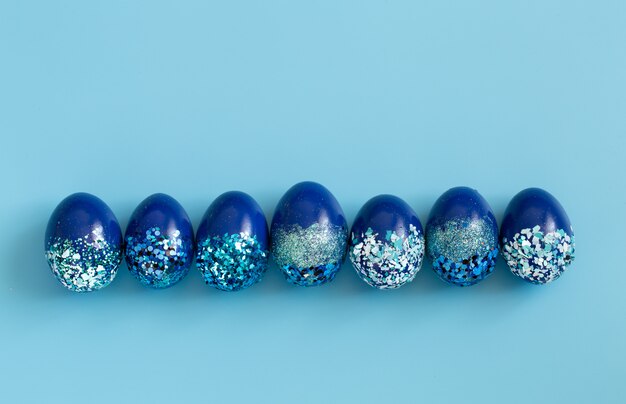 Beau bleu de Pâques avec des oeufs décoratifs bleus en paillettes.