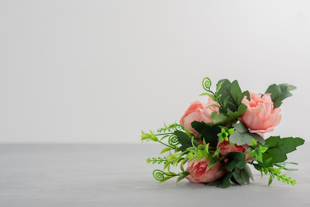 Beau bouquet de fleurs roses sur table grise.