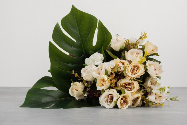 Beau bouquet de roses blanches sur une surface grise.