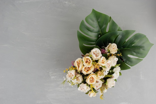 Beau bouquet de roses blanches sur une surface grise.