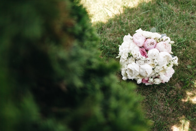 Un beau bouquet de roses est sur l'herbe