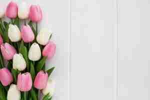 Photo gratuite beau bouquet de tulipes sur un fond en bois blanc avec fond à droite