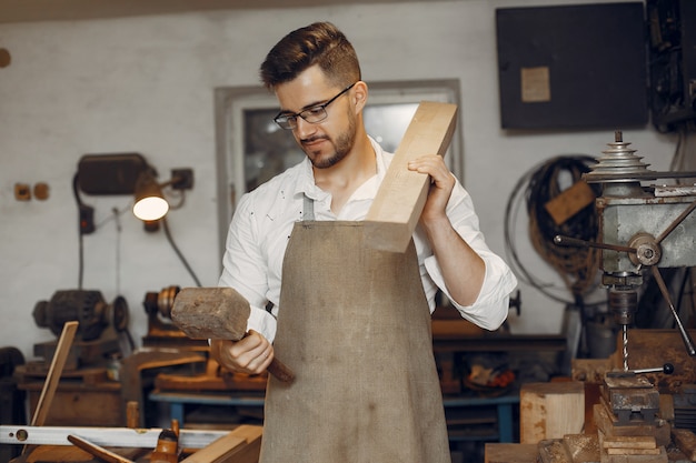 Beau charpentier travaillant avec un bois