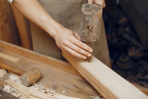 Beau charpentier travaillant avec un bois