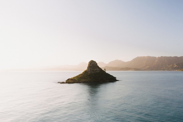 Beau cliché d'une petite île au centre de la mer ouverte avec un paysage de lever de soleil