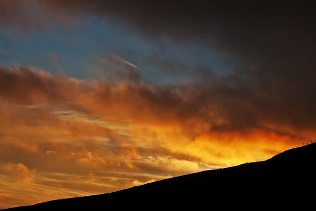 Beau coucher de soleil et soleil orange au-dessus des montagnes