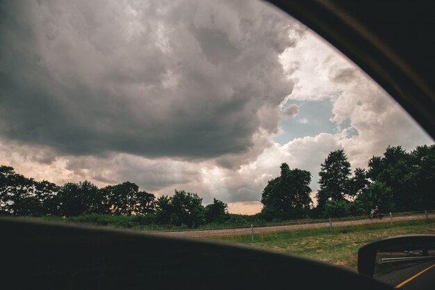 Beau coup de ciel nuageux au-dessus des arbres pris dans une voiture