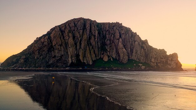 Beau coup de falaises rocheuses près d'une plage avec la lumière du soleil sur le côté