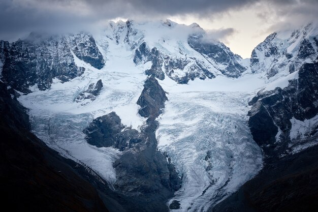 Beau coup d'une montagne enneigée sous un ciel nuageux