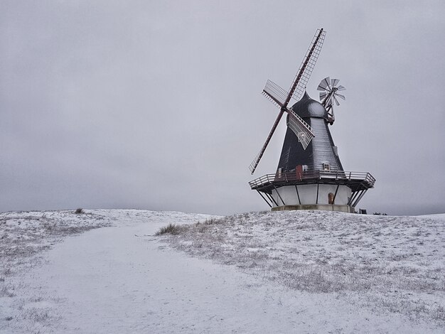 Beau coup d'un moulin à vent au milieu d'un champ d'hiver