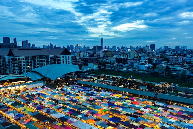 Photo gratuite beau coup de tentes de marché près des bâtiments sous un ciel bleu nuageux