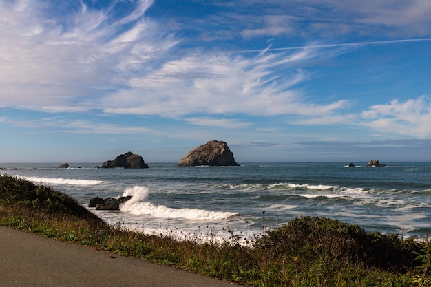 Photo gratuite beau coup de vagues de mousse frappant un bord de mer rocheux