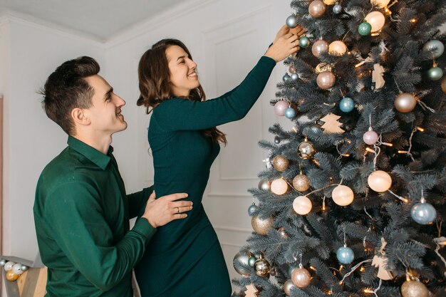 Beau couple amoureux décorer un arbre de Noël