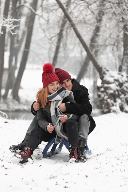 Photo gratuite beau couple assis sur un traîneau