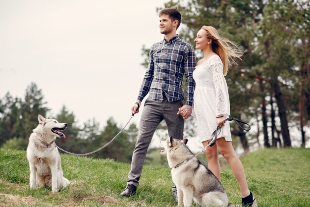 Beau couple dans une forêt en été avec un chien