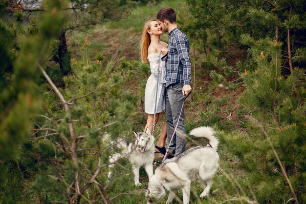 Beau couple dans une forêt en été avec un chien