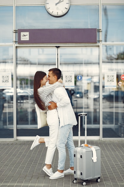Beau couple debout près de l'aéroport