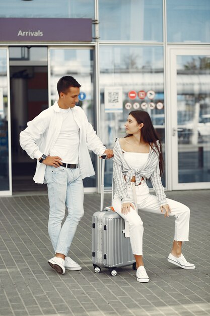 Beau couple debout près de l'aéroport