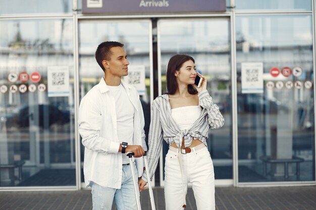 Beau couple debout près de l'aéroport